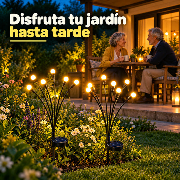 Pareja tomando té en la terraza con el jardín iluminado